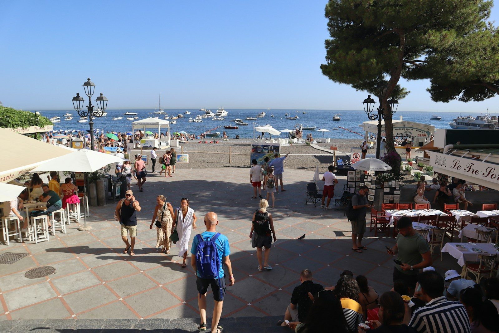 a crowd of people walking around a beach next to the ocean