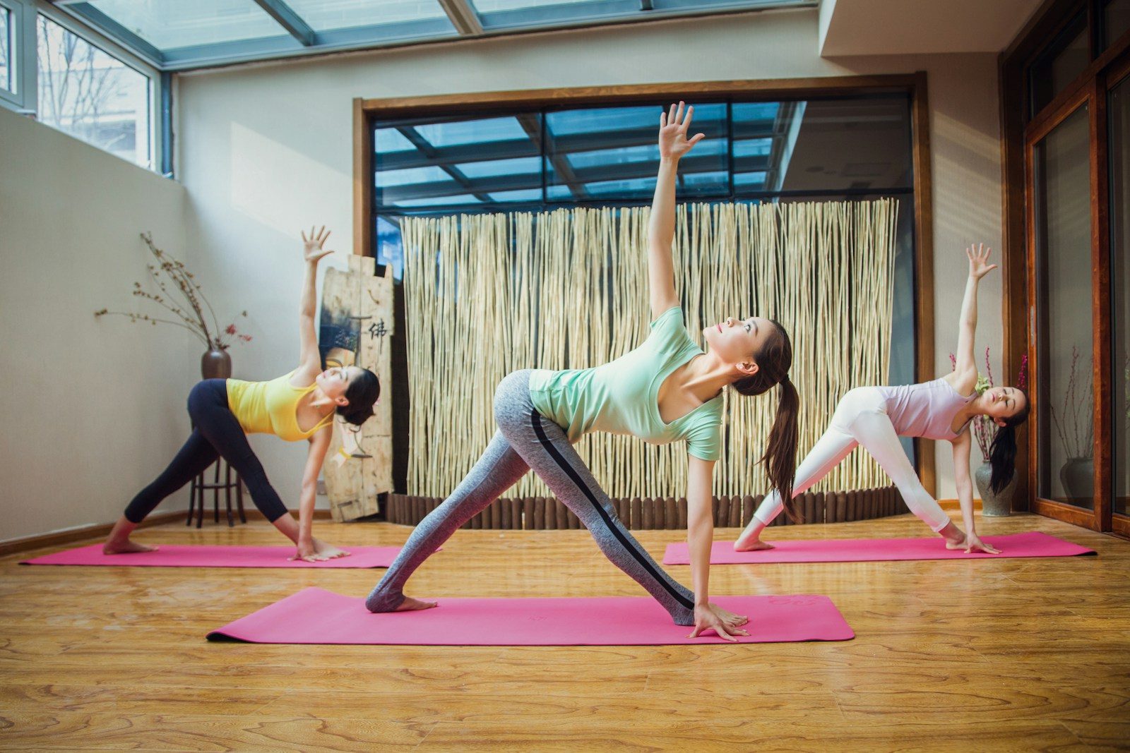 woman in gray tank top and gray leggings doing yoga