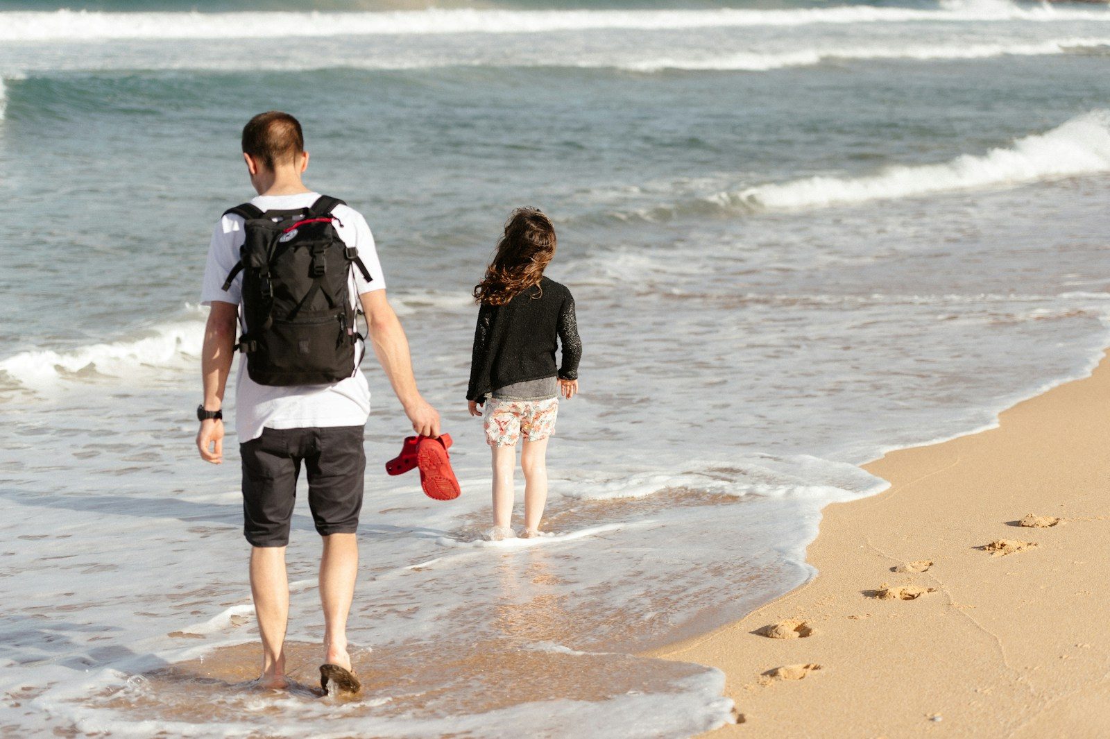 a man and a woman walking on the beach