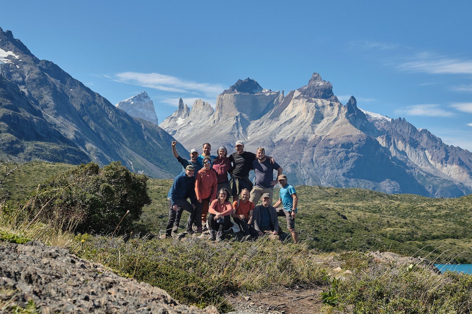 A group of hikers poses in front of majestic mountains.